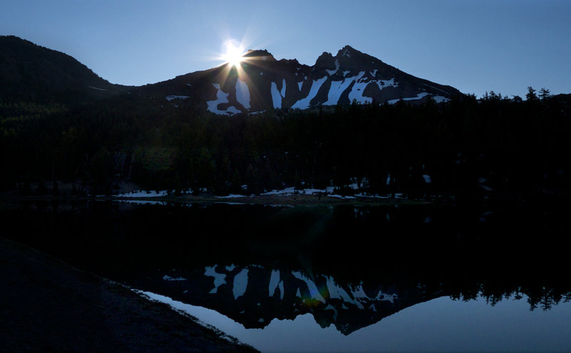 The sun peeking over Broken Top
